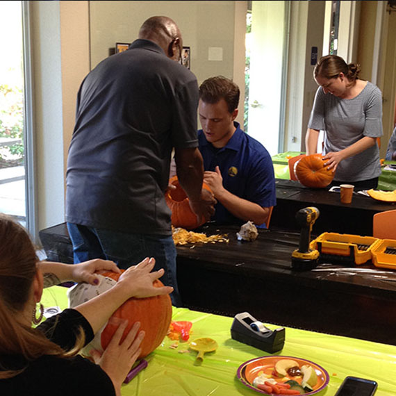 A Group Of People Carving Pumpkins